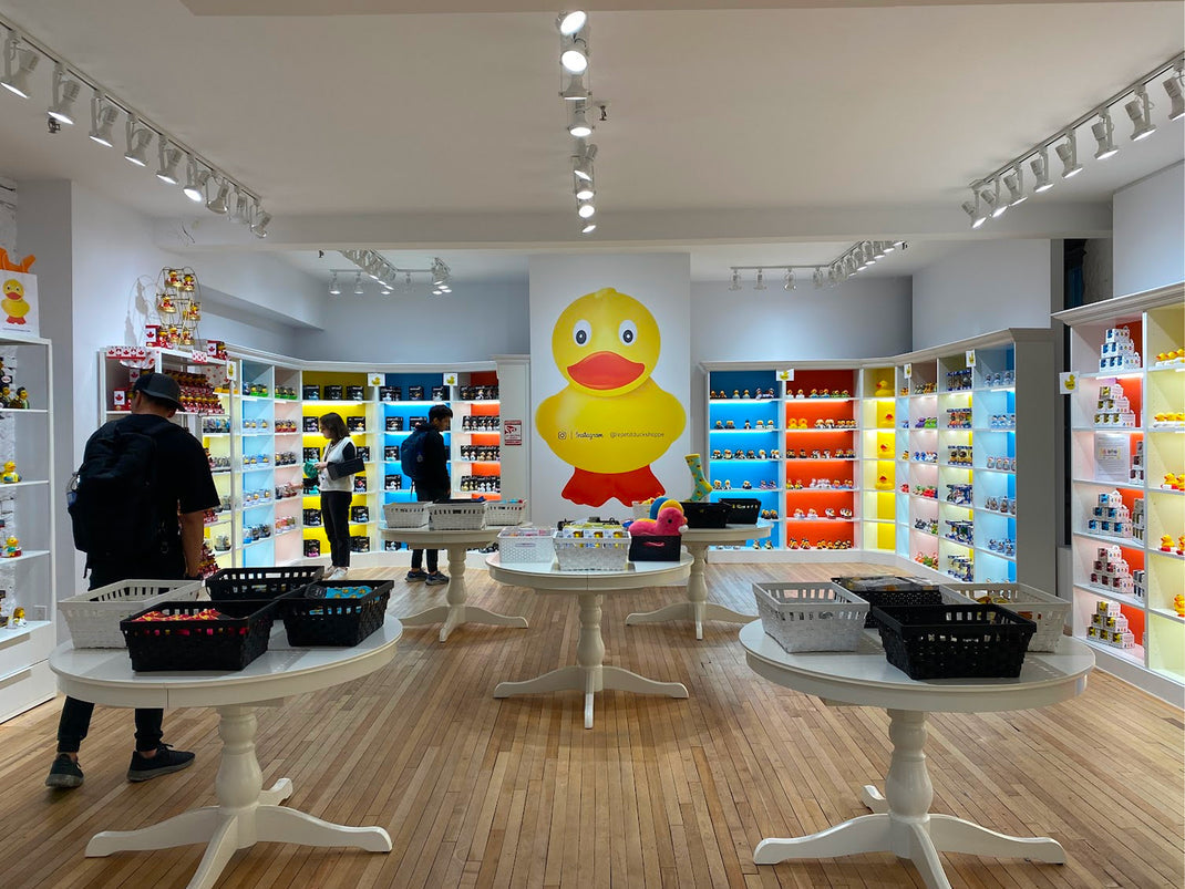 Collectible rubber duck shop interior with colorful shelves and a giant yellow duck wall mural