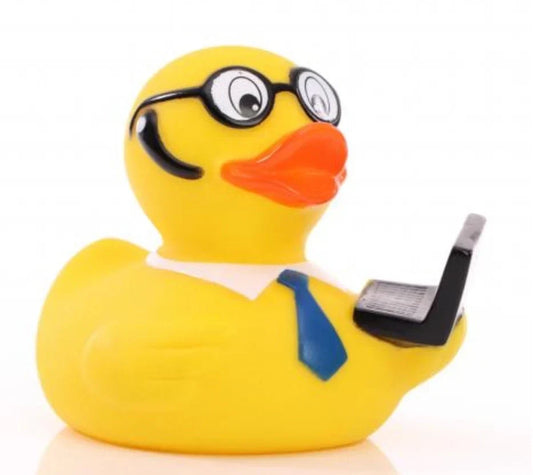  Rubber duck on a desk beside a laptop, representing the rubber duck debugging method.